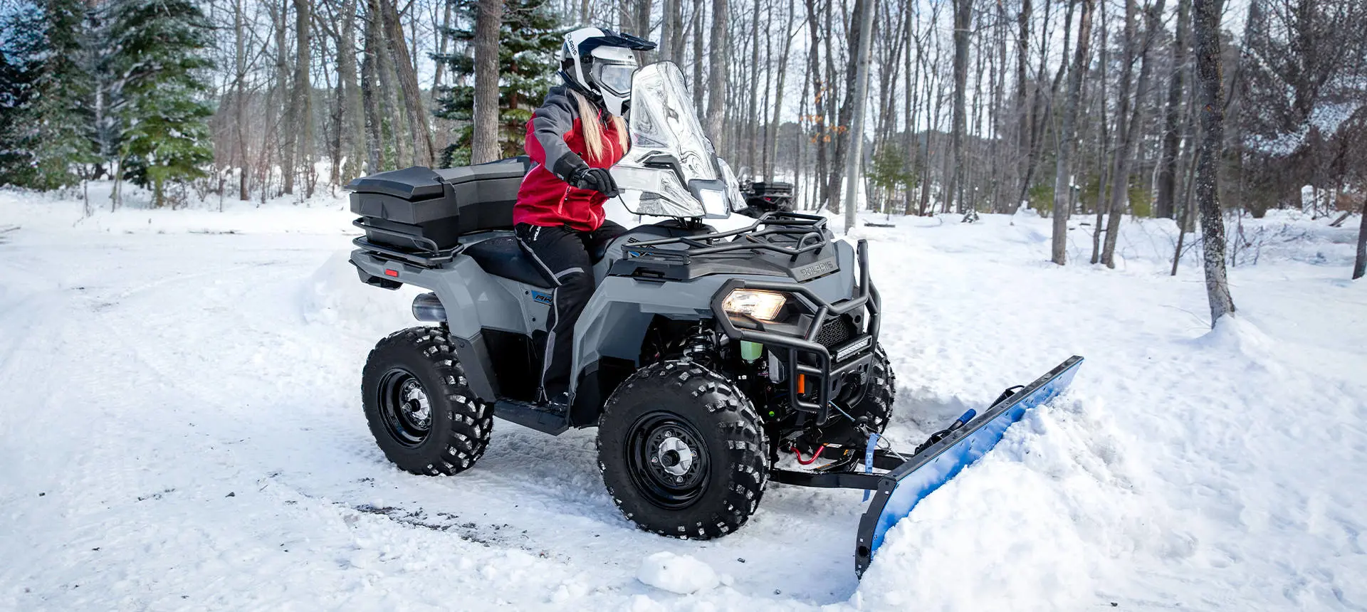 Polaris Sportsman 450 ATV with a plow attached in the winter.