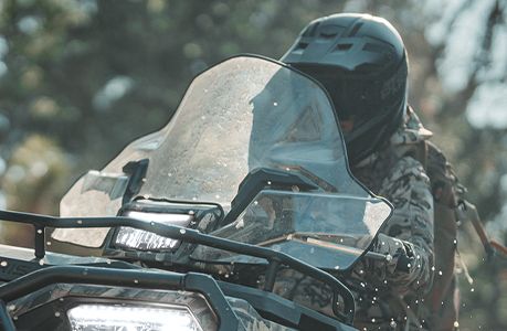 Polaris Sportsman 570 ATV with windshield accessory installed.