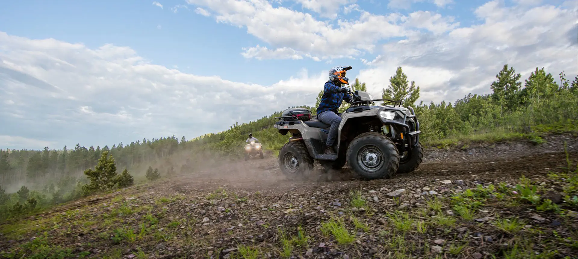 Rider on a Polaris Sportsman 570 ATV cruising on a trail.