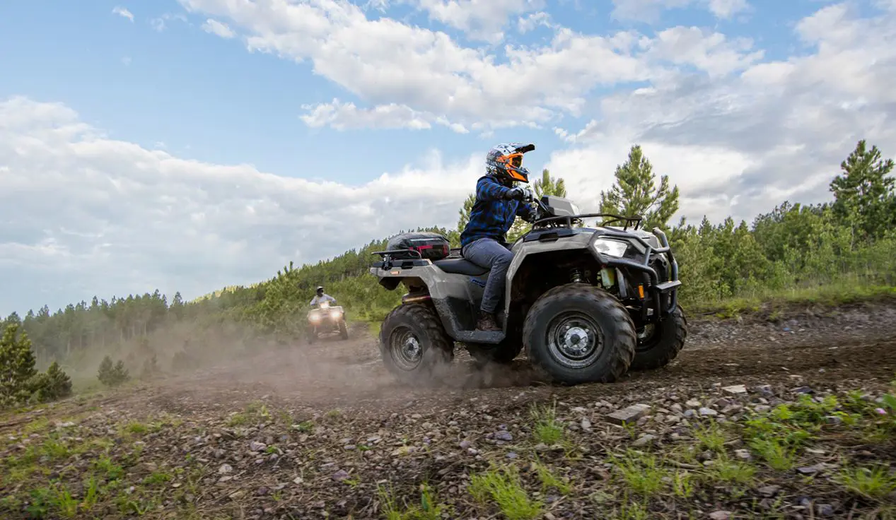 Rider on a Polaris Sportsman 570 ATV cruising on a trail.