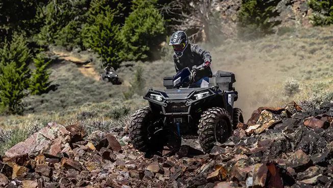 Polaris Sportsman 850 ATV crawling over rocky terrain.