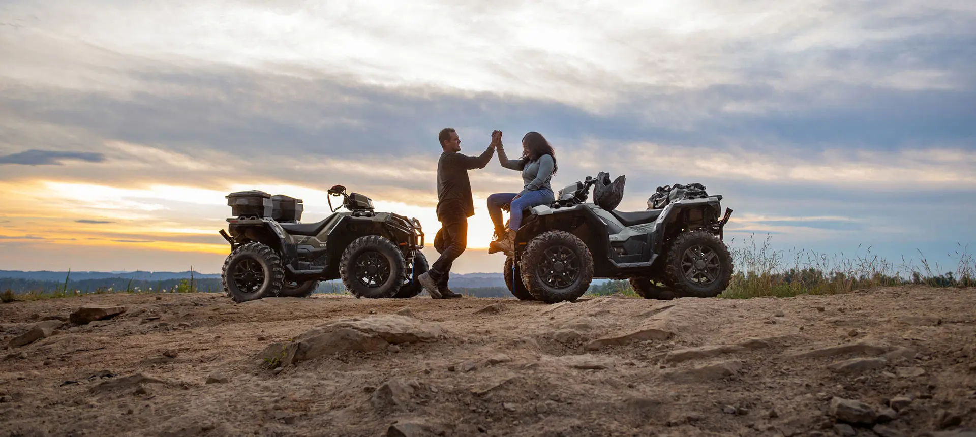 Two riders congratulating each other after a ride on their Polaris Sportsman XP 1000 ATVs.