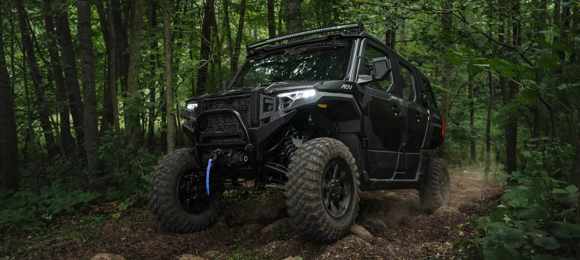A Matte Super Graphite Polaris XPEDITON ADV 5 performance side-by-side crawling over rocky terrain.