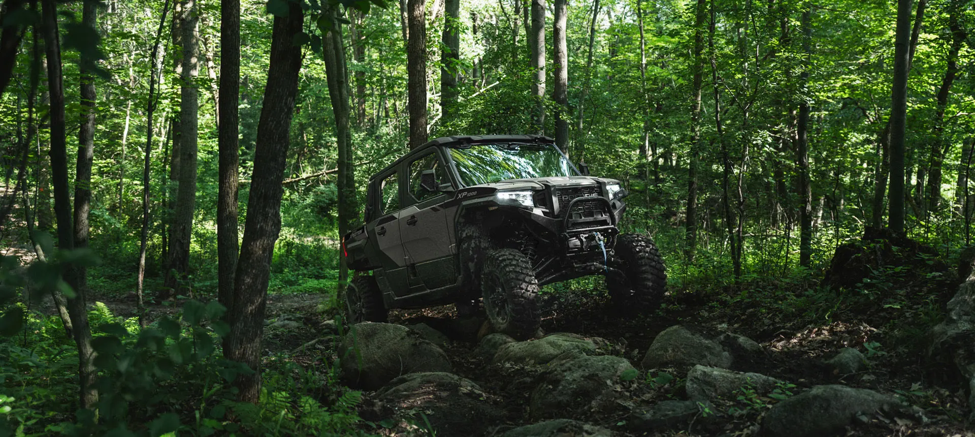 A Slate Gray Polaris XPEDITION XP 5 NorthStar side-by-side crawling over rocky terrain.
