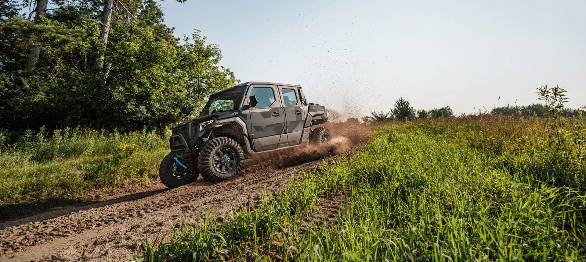 A Matte Super Graphite Polaris XPEDITION XP 5 NorthStar side-by-side cruising on a trail.