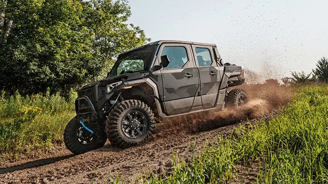 A Matte Super Graphite Polaris XPEDITION XP 5 NorthStar side-by-side cruising on a trail.