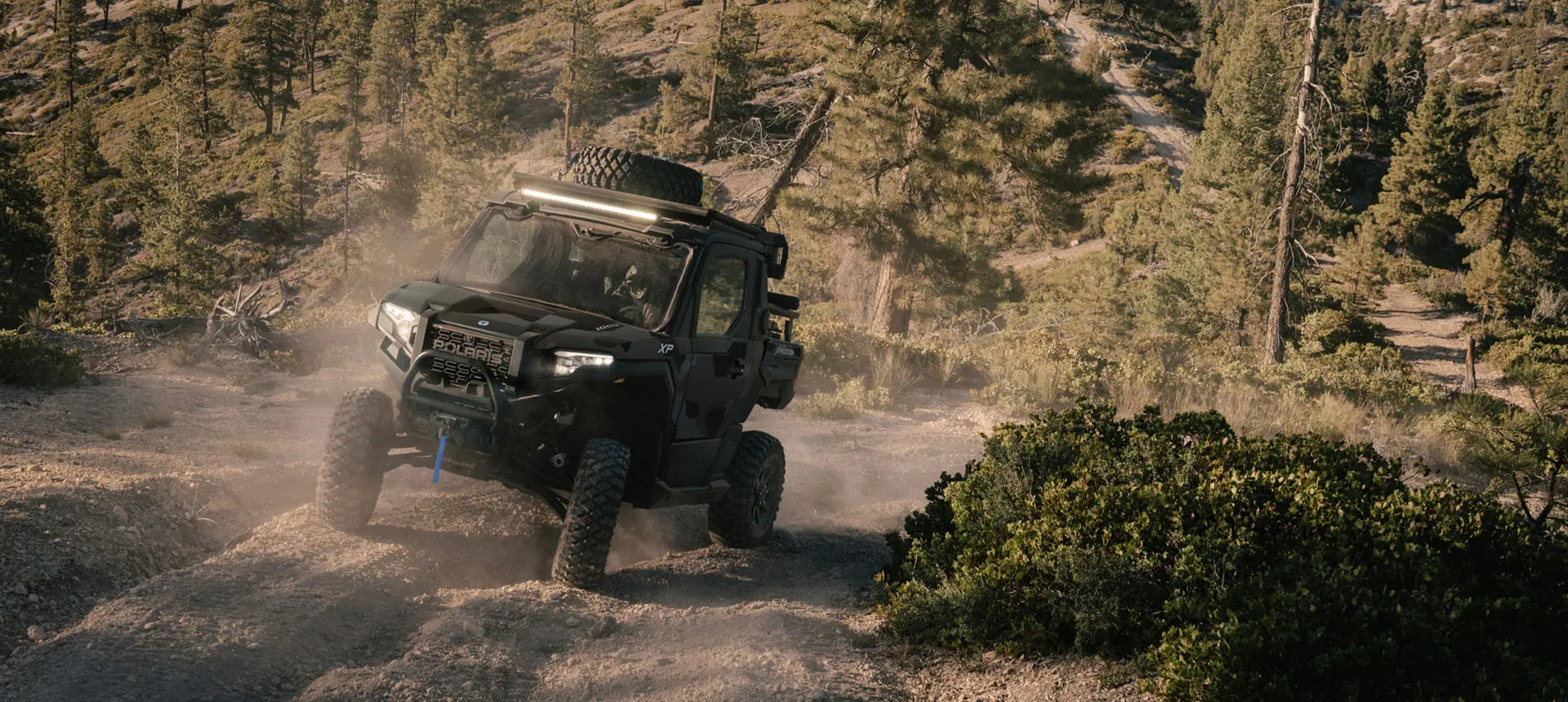 A Matte Super Graphite Polaris XPEDITION XP NorthStar side-by-side on a trail with deep grooves.