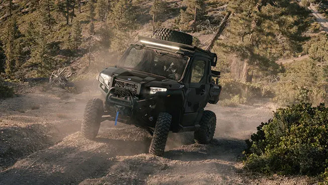 A Matte Super Graphite Polaris XPEDITION XP NorthStar side-by-side on a trail with deep grooves.