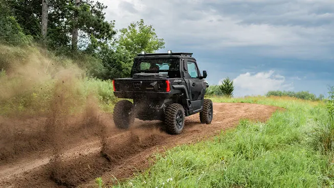 Rear view of a Matte Super Graphite Polaris XPEDITION XP NorthStar side-by-side driving on a trail.