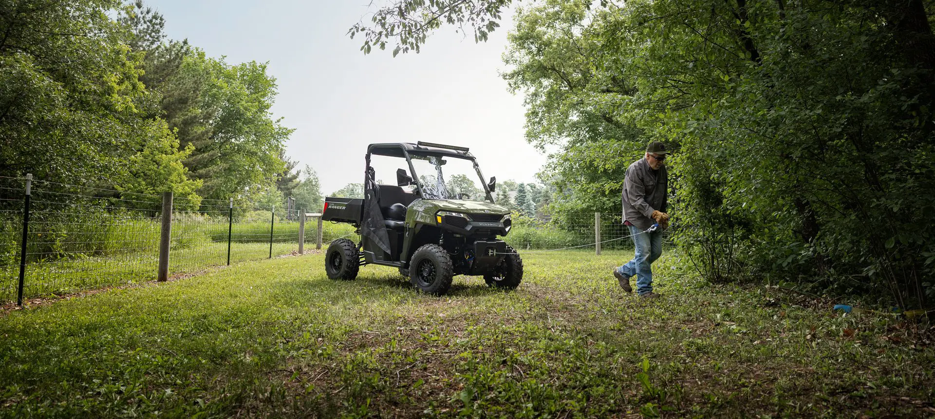 A man pulling out the winch from the front end of his Polaris RANGER 500 UTV.