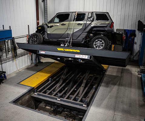 Polaris XPEDITION ADV 5 SxS positioned on a tilting stability test platform inside a testing facility, evaluating performance on extreme side-slope angles.