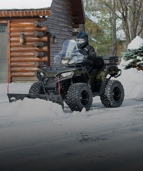 Polaris Sportsman ATV being used to plow snow for maintenance uses.