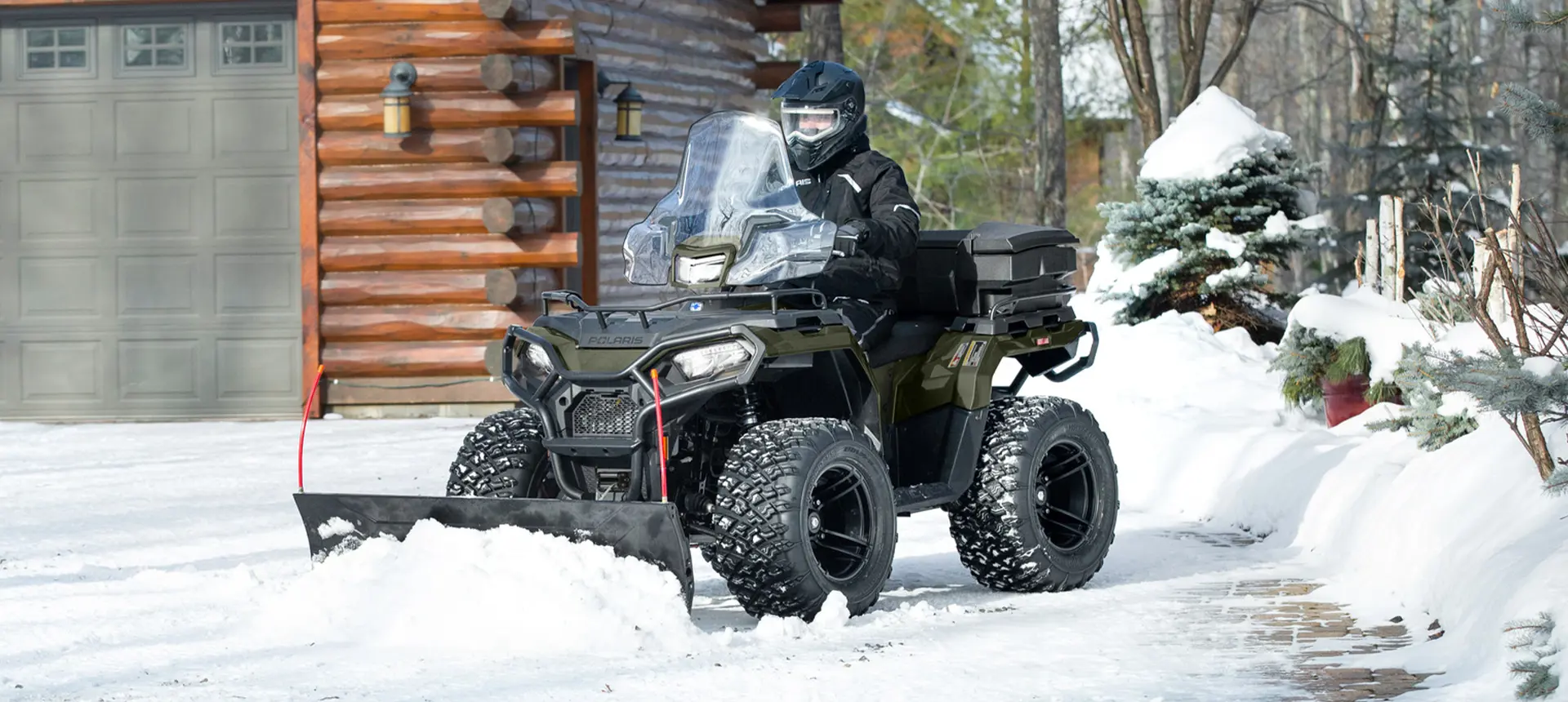 Person using a Polaris Sportsman ATV for snow removal, and grounds and facility operations.