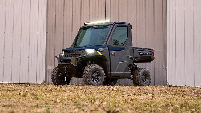 Side profile of a Polaris RANGER 1000 CAB UTV with illuminated for lights.