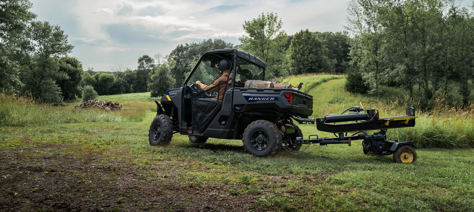 A Polaris RANGER 1000 UTV pulling a log splitter attached to the rear hitch.