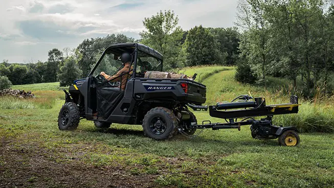 A Polaris RANGER 1000 UTV pulling a log splitter attached to the rear hitch.