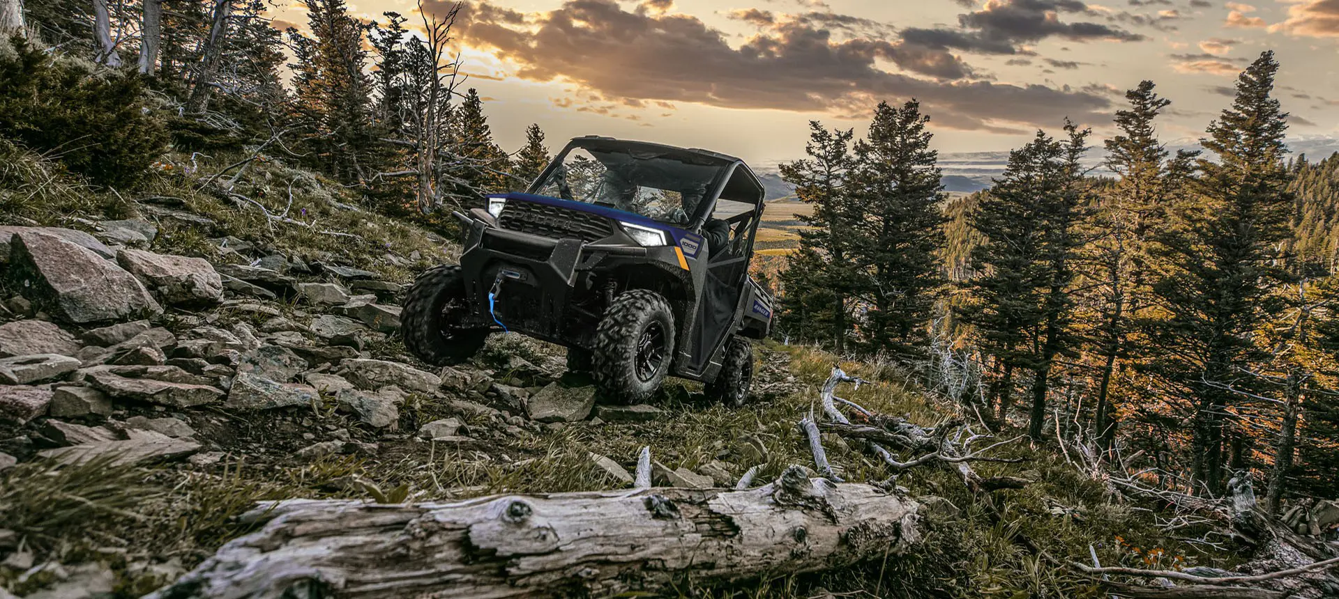 A Polaris RANGER 1000 UTV climbing over rocky terrain.