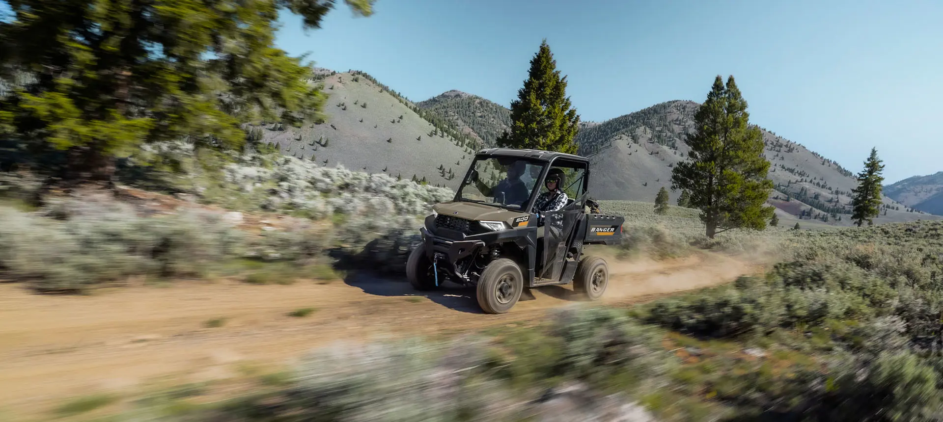 A Polaris RANGER 600 UTV driving on a trail.