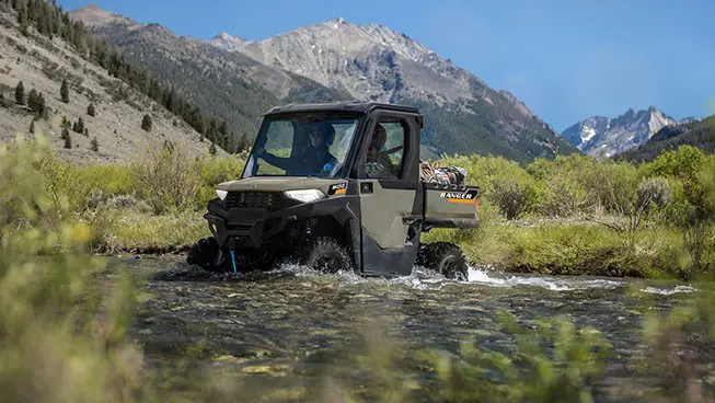 A Polaris RANGER 600 NorthStar UTV driving through a shallow stream.