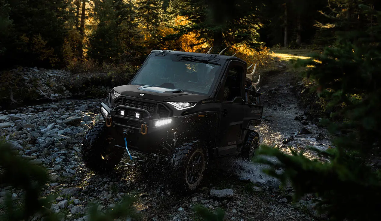 Polaris RANGER XD 1500 NorthStar extreme duty UTV climbing over wet rocky terrain with ease.