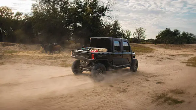 A Polaris RANGER XD 1500 NorthStar Texas Edition extreme duty UTV driving through a cattle pasture.