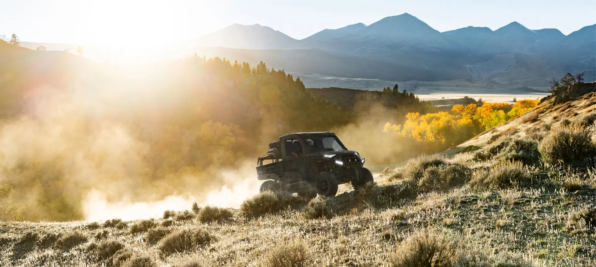 A Polaris RANGER  XD 1500 NorthStar extreme duty UTV driving uphill in the morning.