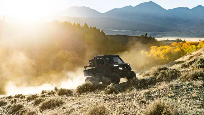 A Polaris RANGER  XD 1500 NorthStar extreme duty UTV driving uphill in the morning.