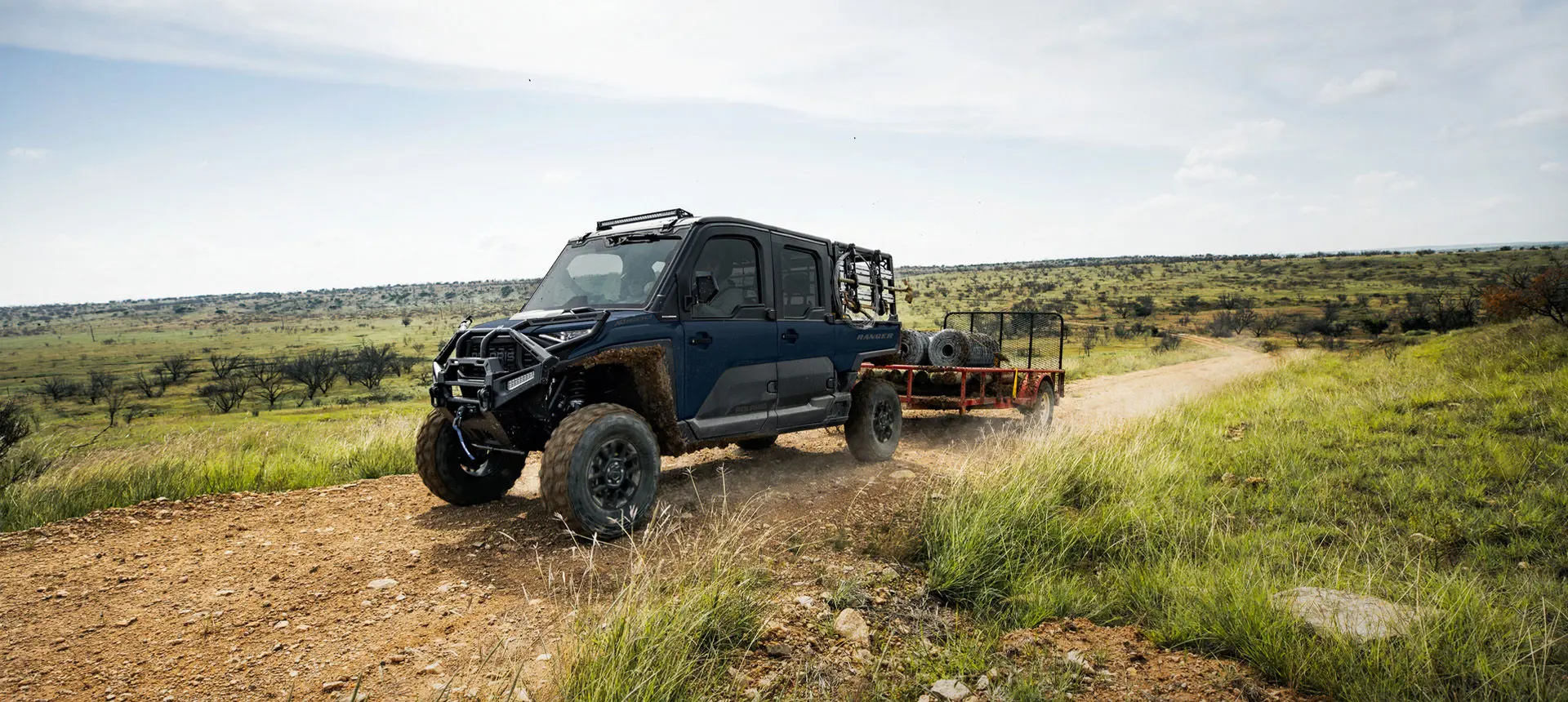 A Polaris RANGER CREW XD 1500 NorthStar Edition extreme duty UTV pulling a heavy trailer with ease.