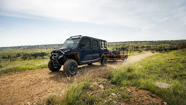 A Polaris RANGER CREW XD 1500 NorthStar Edition extreme duty UTV pulling a heavy trailer with ease.
