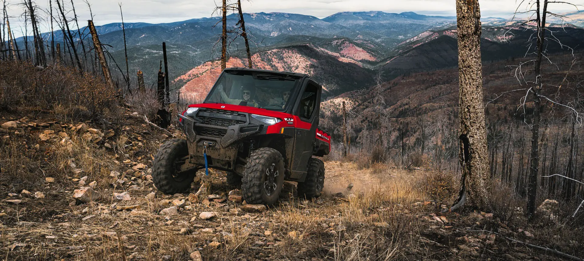 A Polaris RANGER XP 1000 NorthStar UTV driving over rocky terrain on a trail.