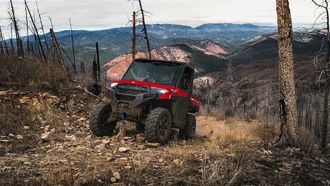 A Polaris RANGER XP 1000 NorthStar UTV driving over rocky terrain on a trail.