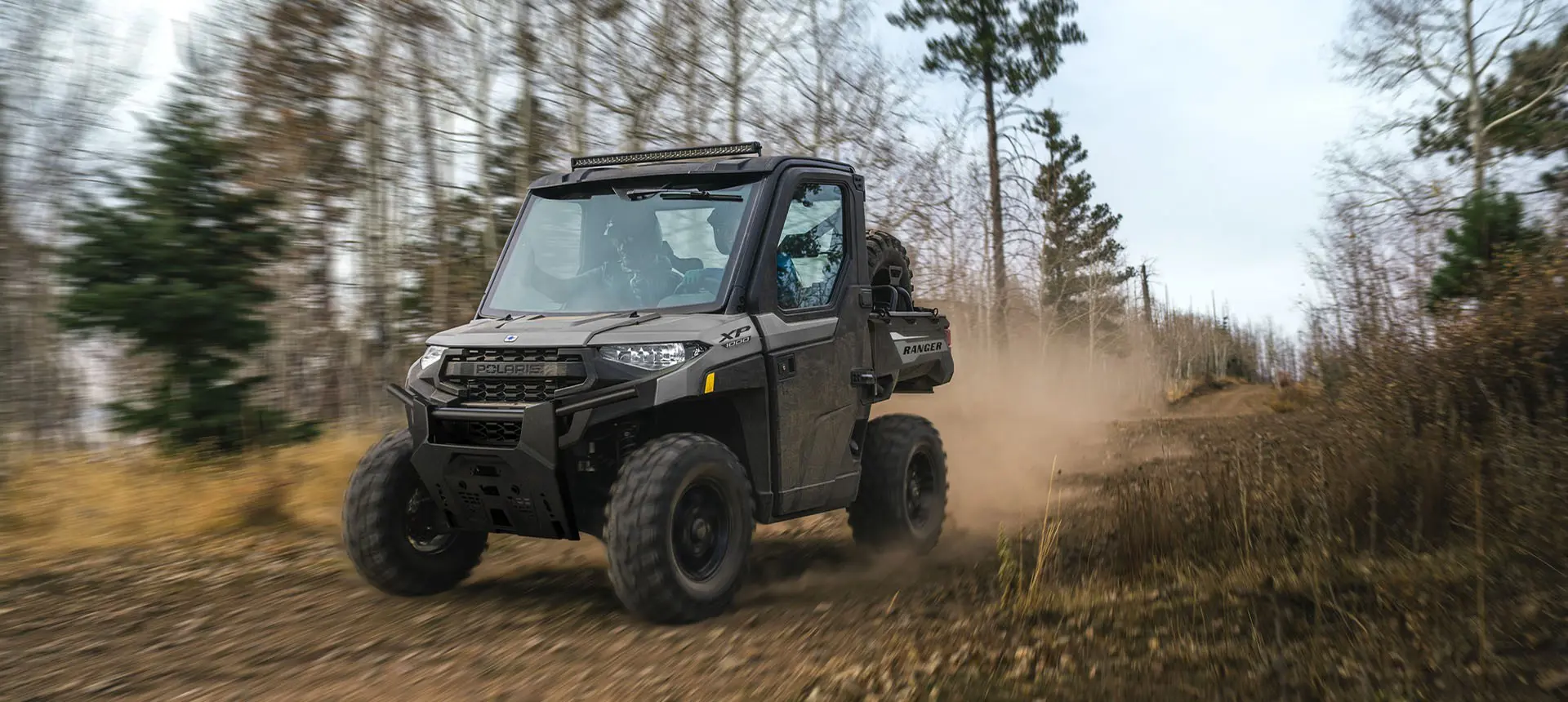 2 riders in a Polaris RANGER XP 1000 NorthStar UTV cruising on a trail.