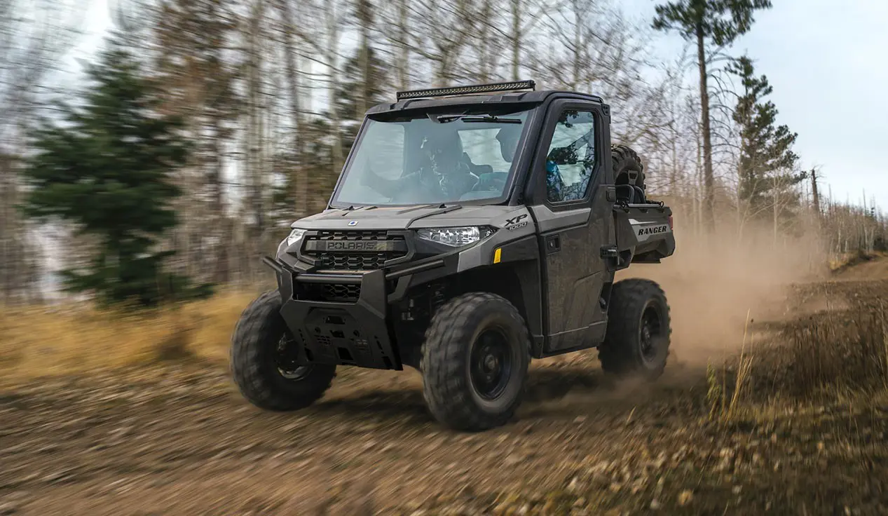 2 riders in a Polaris RANGER XP 1000 NorthStar UTV cruising on a trail.