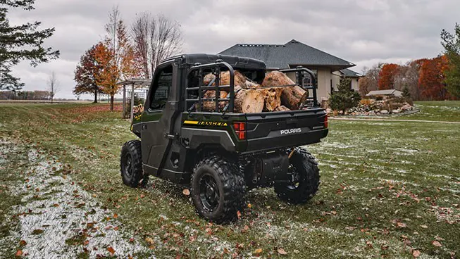 Rear-view of a Polaris RANGER XP 1000 NorthStar UTV hauling wood in the cargo box.