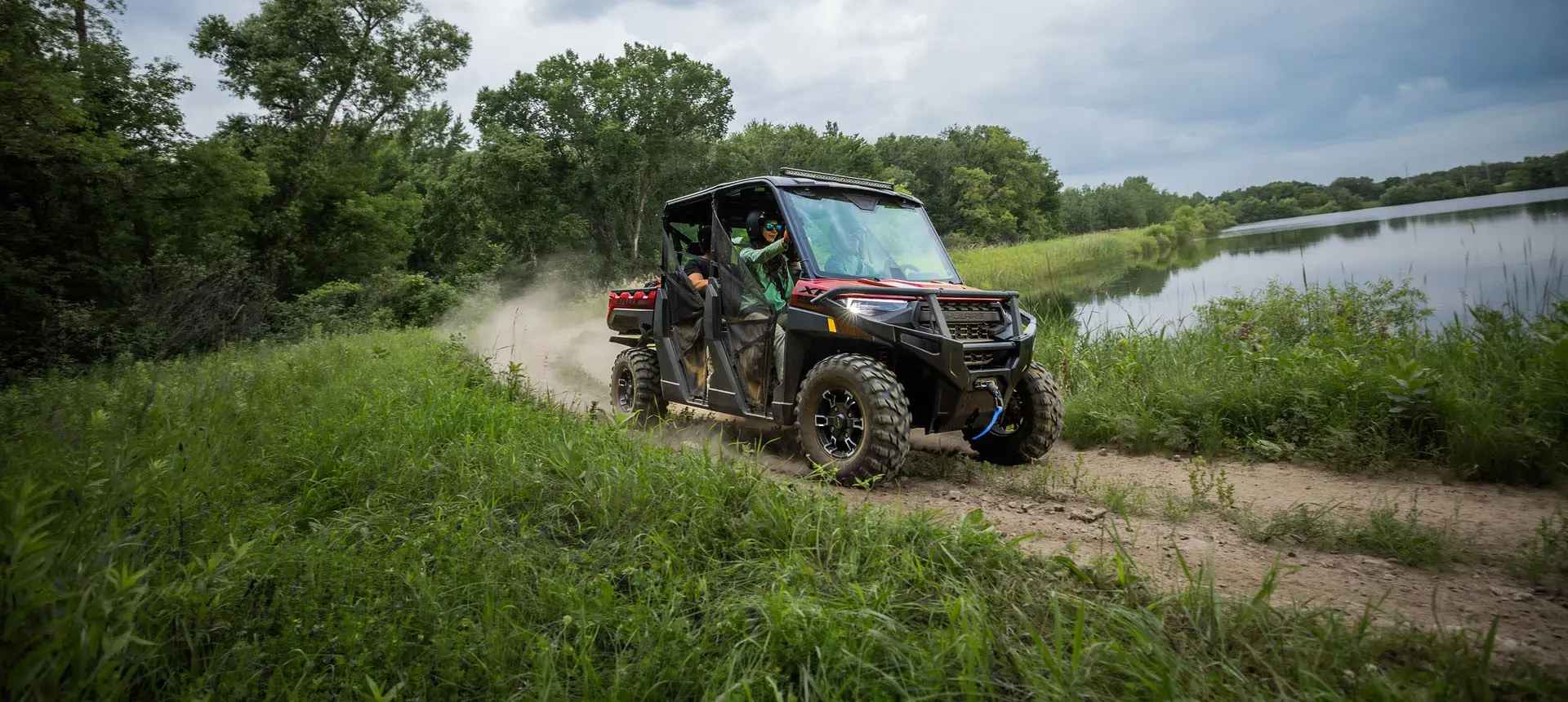 A Polaris RANGER CREW XP 1000 driving on a trail around a lake.