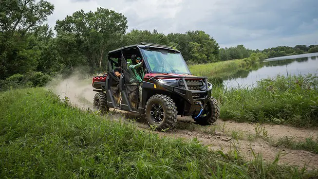 A Polaris RANGER CREW XP 1000 driving on a trail around a lake.