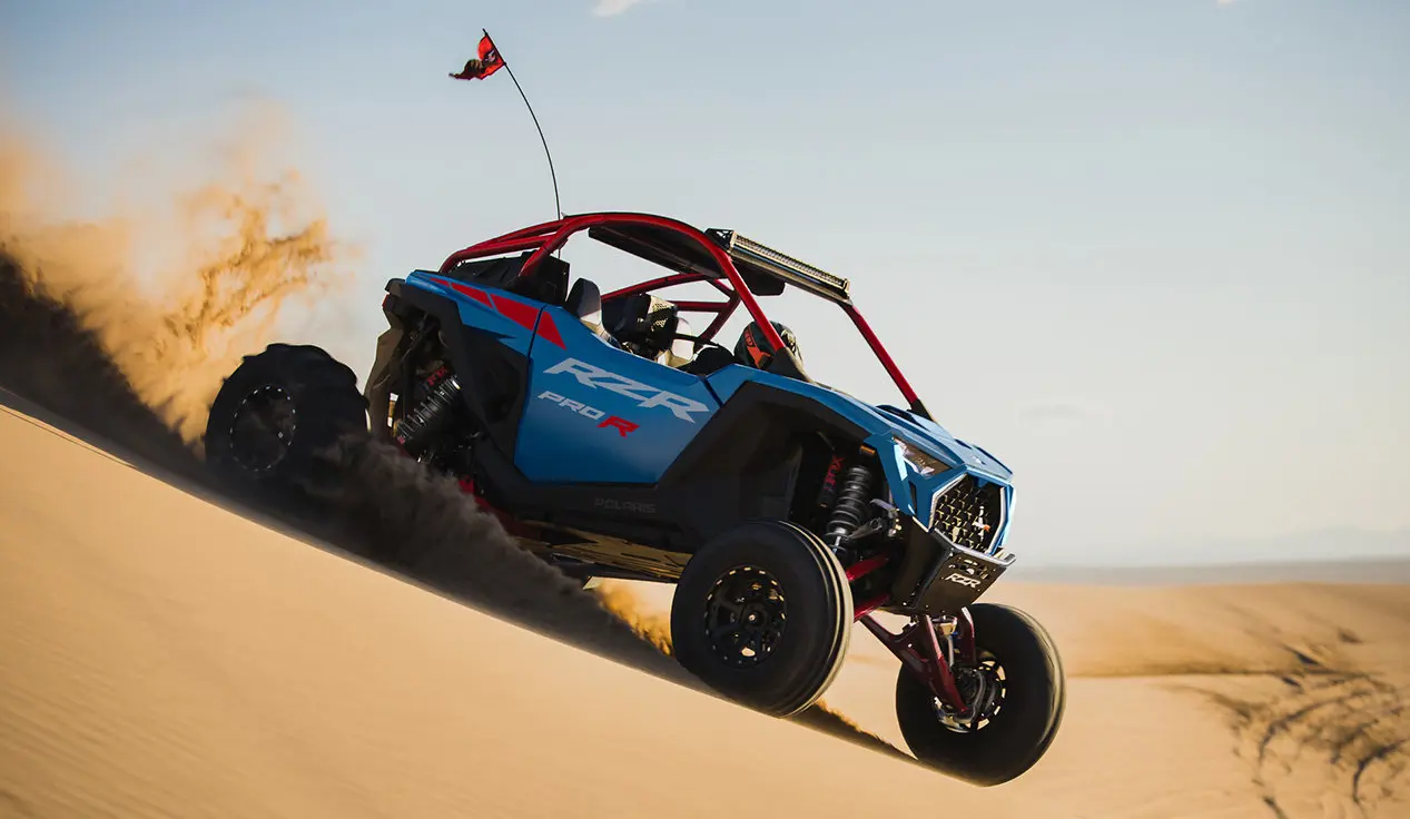 A Freedom Blue Polaris RZR Pro R side-by-side driving in the dunes.