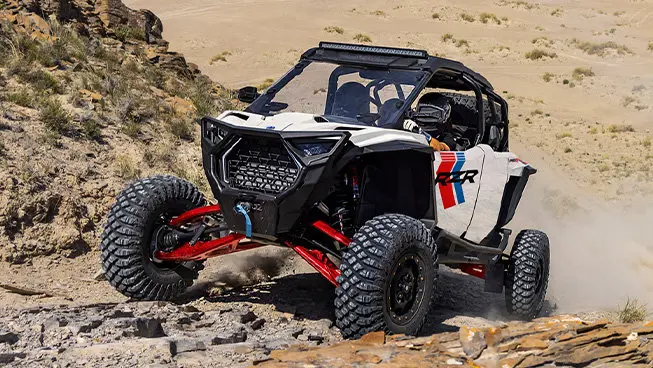 Polaris RZR Pro S side-by-side climbing over rocky terrain.