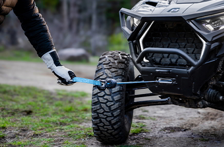 A winch being pulled out of the front end of a Polaris RZR Pro XP side-by-side.