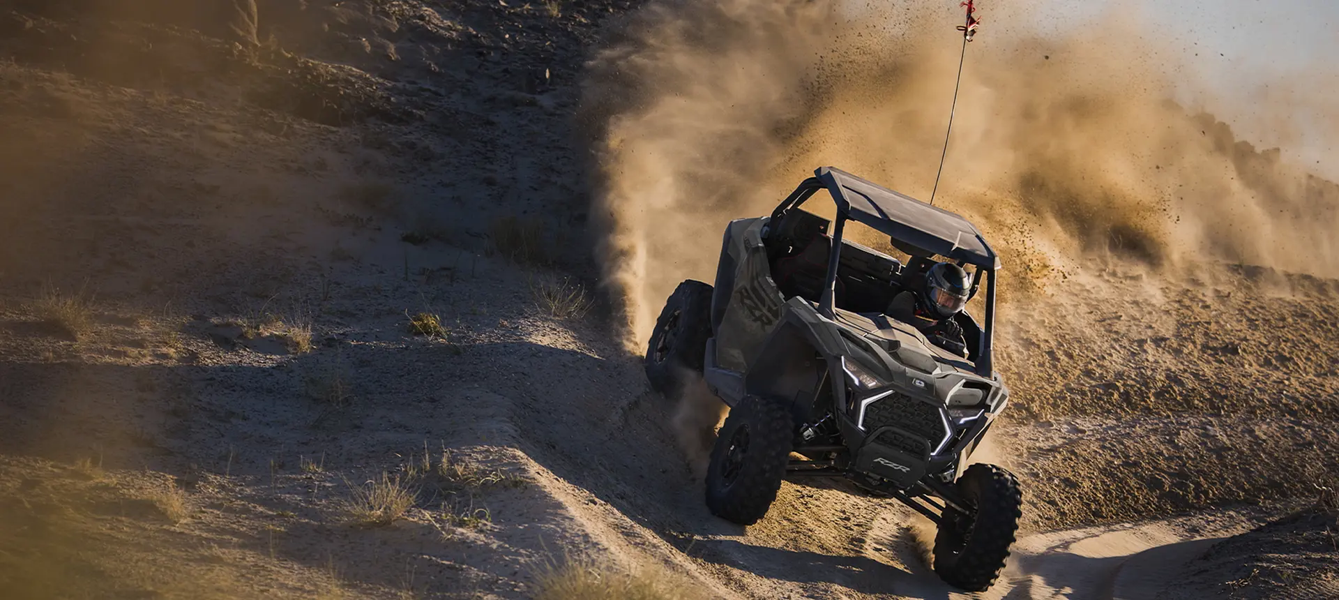A Polaris RZR Pro XP side-by-side cornering in the desert.
