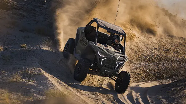 A Polaris RZR Pro XP side-by-side cornering in the desert.