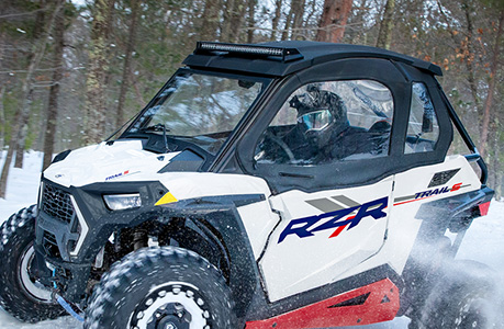 A Polaris RZR Trail side-by-side with canvas upper door accessories installed.