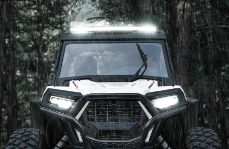 A Polaris RZR Trail side-by-side with lighting accessories installed.