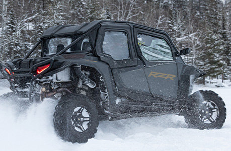 A Polaris RZR XP 4 side-by-side with canvas upper door accessories installed.