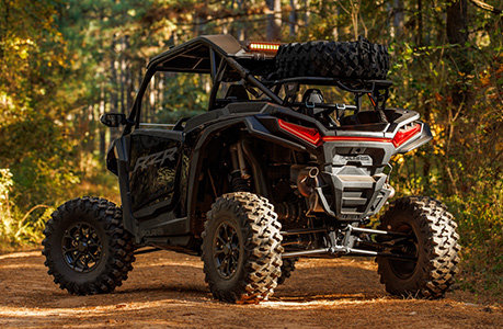 A Polaris RZR XP side-by-side with a spare tire carrier accessory installed.