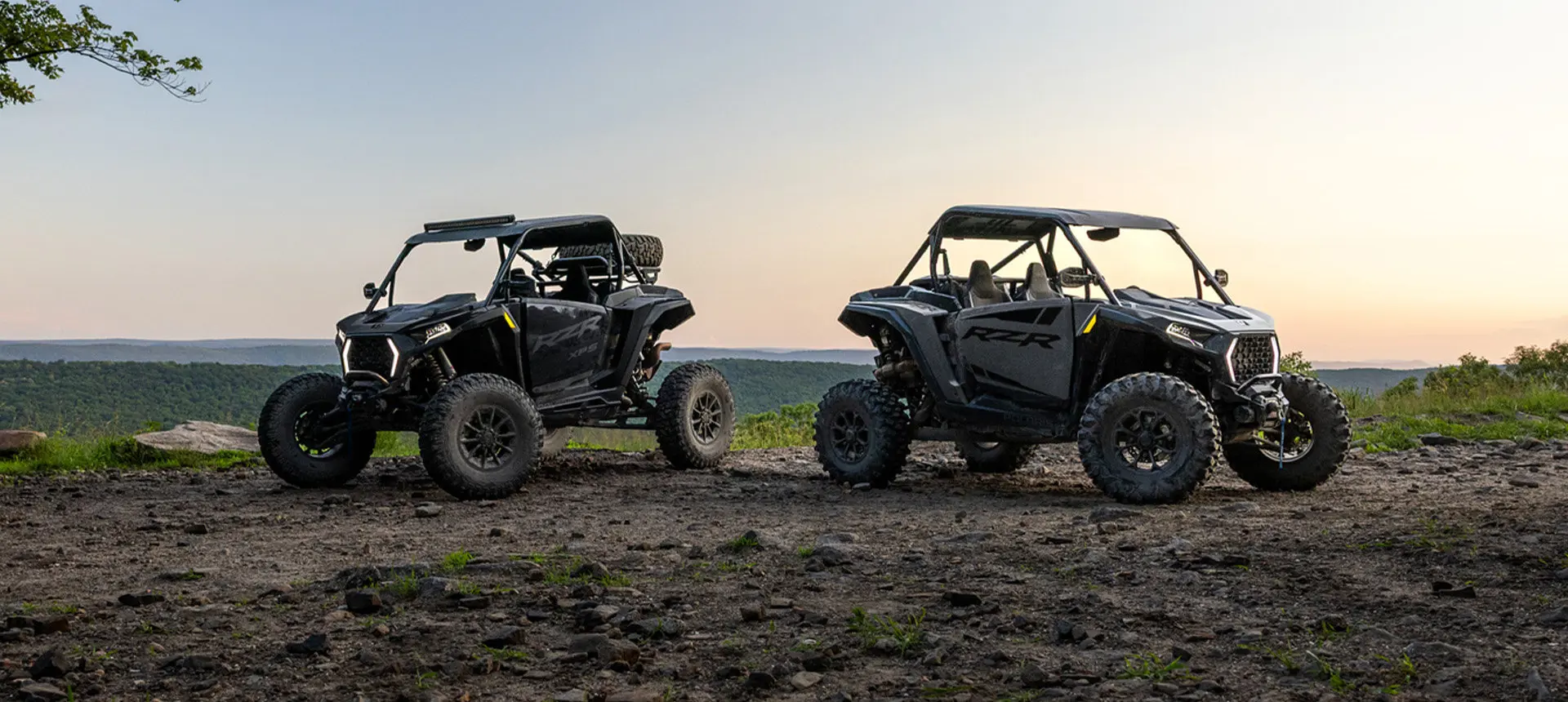 A Polaris RZR XP and RZR XP S side-by-side parked on a ridge.
