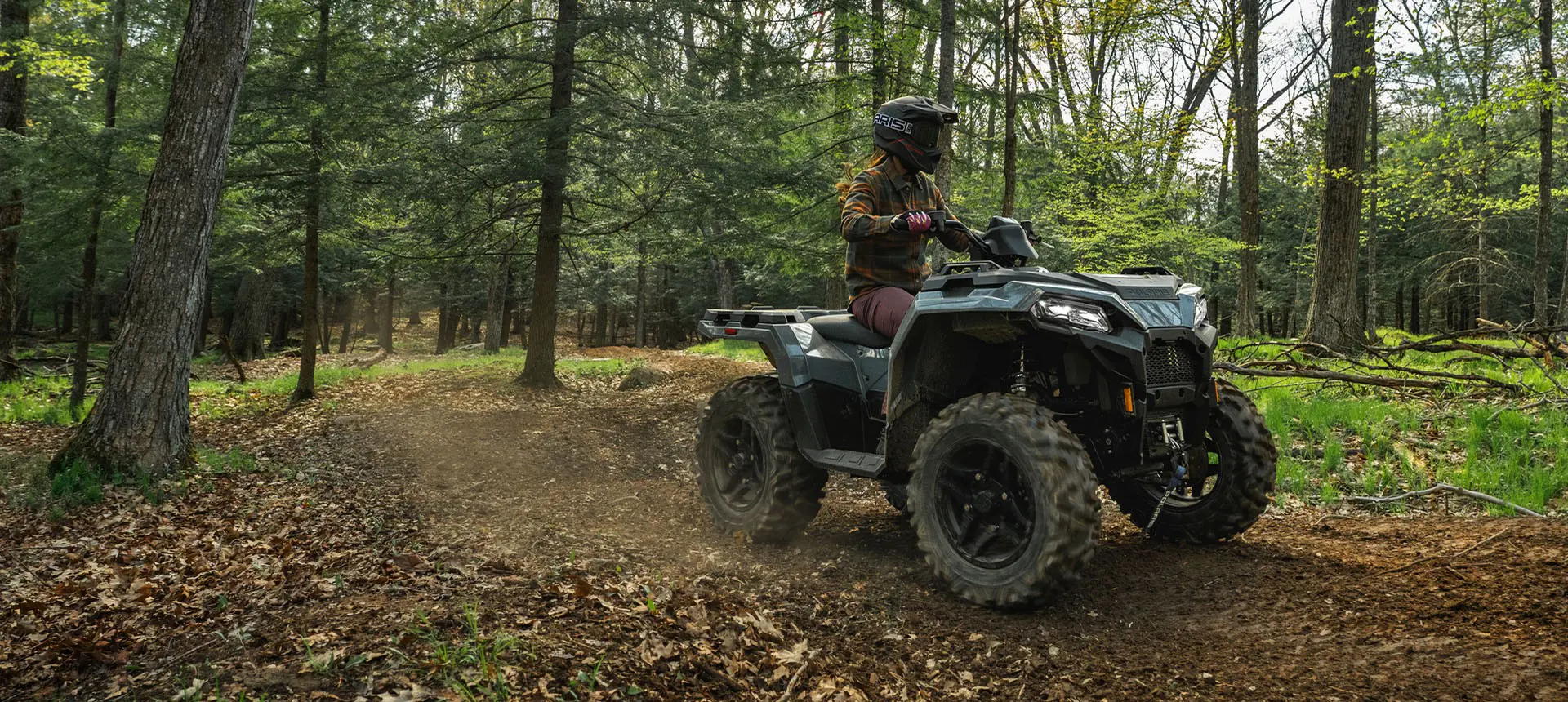 Rider on a Polaris Sportsman 500 ATV cruising on a trail.