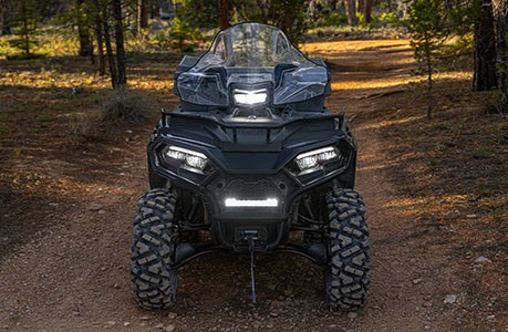 Polaris Sportsman 600 ATV with windshield and lighting accessories installed.