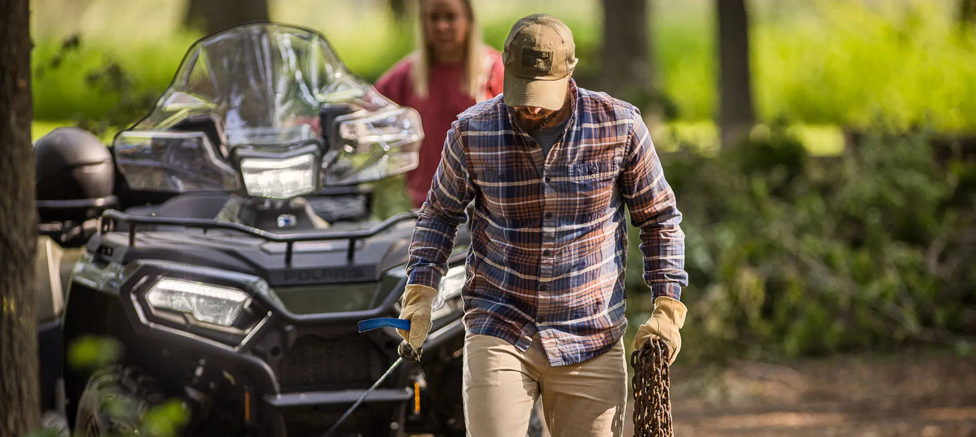 Man using the winch from the front-end of his Polaris Sportsman 6x6 600 ATV.