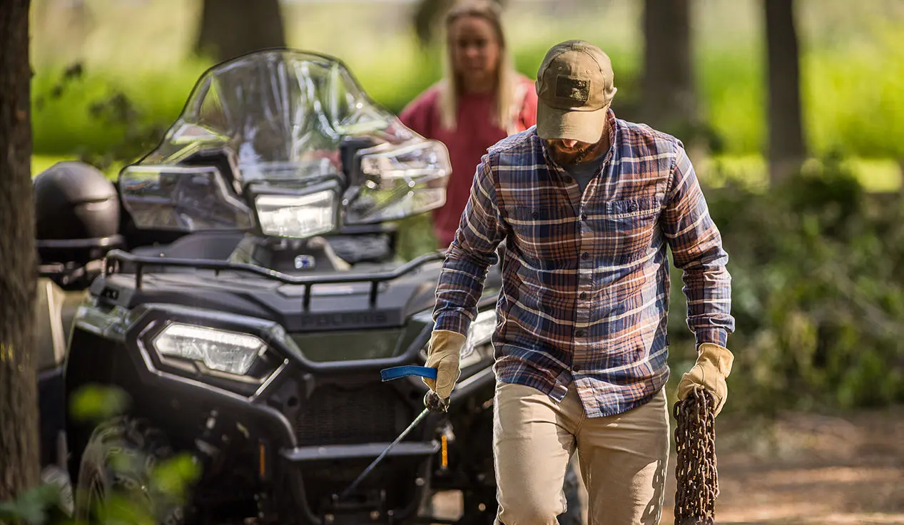 Man using the winch from the front-end of his Polaris Sportsman 6x6 600 ATV.